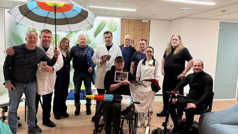 Foto: Ukraine wir kommen / Mehrere Veteranen am Krankenhaus Nr. 2 im westukrainischen Riwne, der Klinikdirektor, Chirurg, Betreuerin, Übersetzerin und vier Fahrer freuen sich über die "Bogenspende" des DSB.