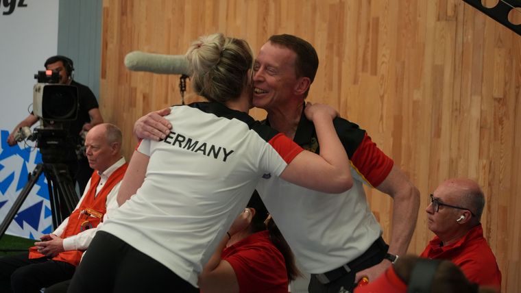 Foto: ISSF / Glückwunsch, Josefin Eder. Hier beglückwünscht Co-Trainer Thomas Zerbach der Sportpistolen-Schützin.