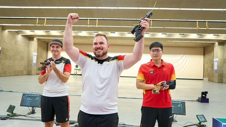 Foto: ISSF / Strahlender Sieger nach elfjähriger Wartezeit: Oliver Geis gewann in Hangzhou vor Teamkollege Emanuel Müller und dem Chinesen Shiyu He.