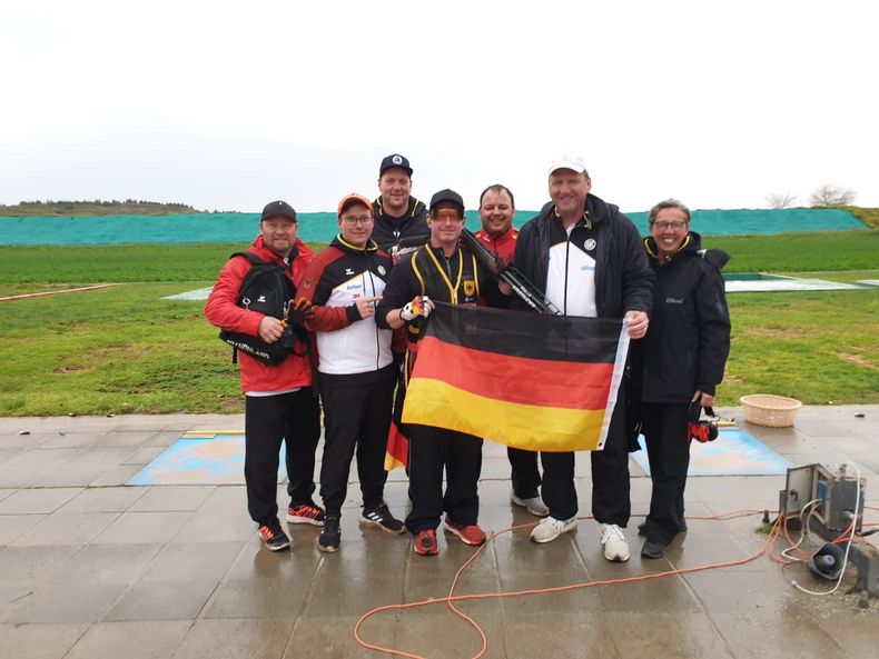 Foto: DSB / Bundestrainer Uwe Möller (2. v.r.) und die übrige deutsche Trap-Delegation beglückwünschen Andreas Löw.