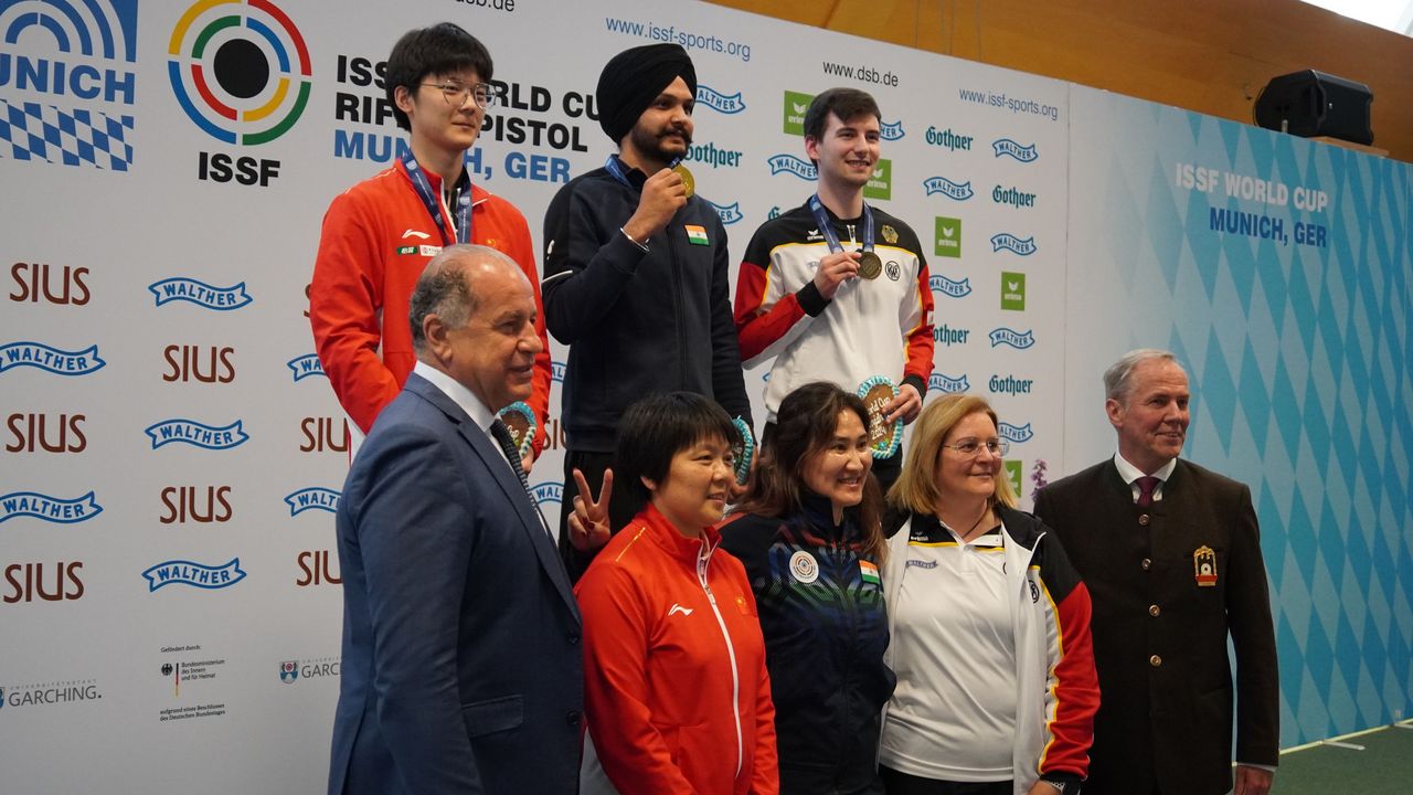 Foto: DSB / Das Luftpistolen-Podium mit Robin Walter (oben rechts), den Trainern sowie den Präsidenten Luciano Rossi (ISSF) und Hans-Heinrich von Schönfels (DSB).