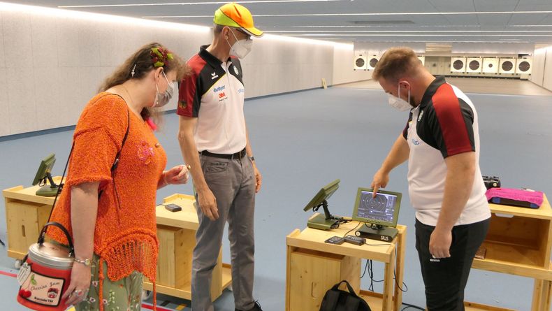 Foto: DSB / Tokio-Teilnehmer Oliver Geis und Schnellfeuerpistolen-Bundestrainer Detlef Glenz im Gespräch mit Staatssekretärin Andrea Milz.