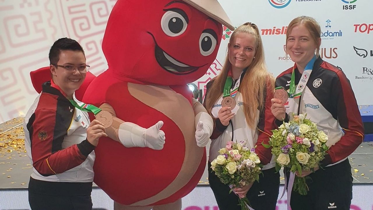 Foto: DSB / Lisa Müller, das WM-Maskottchen, Anna-Lena Geuther und Veronique Münster freuen sich über doppelt Team-Bronze.