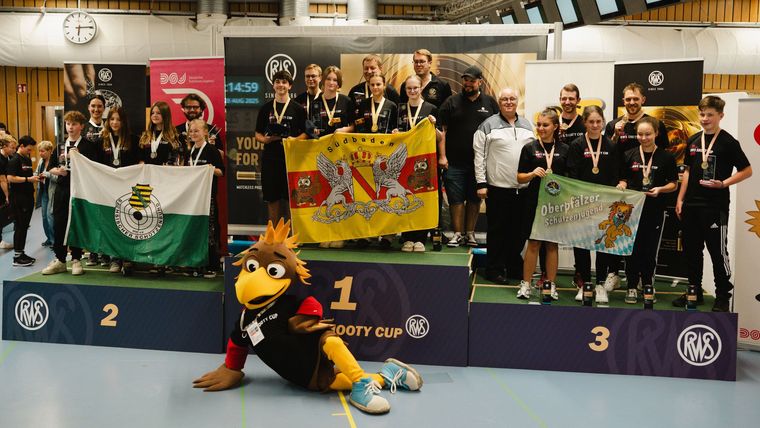 Foto: DSJ / Die siegreichen Teams mit den Spitzenschützen sowie DSJ-Maskottchen Shooty.